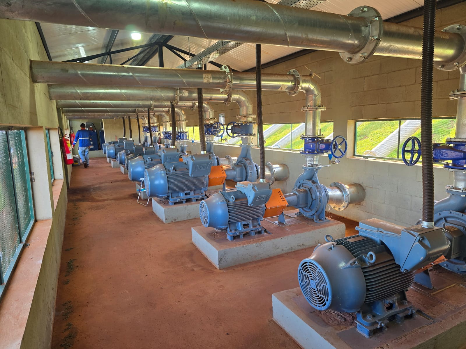 Interior de casa de bombas com motores e tubulações